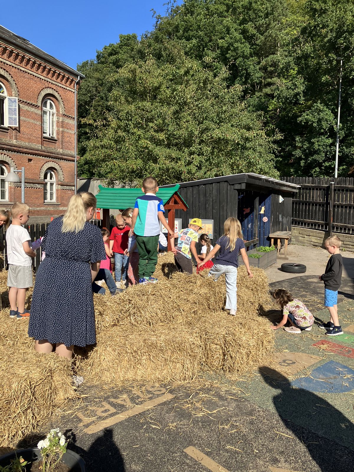 Børn leger i halm i Børnehaven Dragonvej